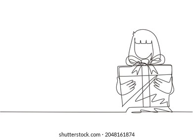 Una sola línea dibujando a una tierna chica sosteniendo una gran caja de regalo envuelta en el lazo de la cinta delante de ella en brazos. Niña lleva regalo de vacaciones con un gran arco rojo en sus manos. Vector de diseño de traza de línea continua