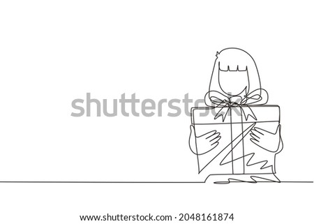 Single one line drawing cute girl holding big ribbon bow wrapped gift box in front of her in arms. Little girl carries holiday gift with big red bow in her hands. Continuous line draw design vector