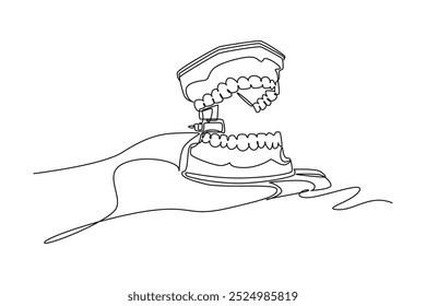 Single one line drawing of doctor or dentist hand holding anatomical complete adult human teeth set. Medical internal anatomy education concept. Continuous line draw design graphic vector illustration