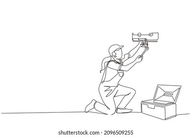 Single one line drawing female plumber in overall is installing water heater or boiler. Home repair, maintenance and plumbing services. Handywoman concept. Continuous line draw design graphic vector