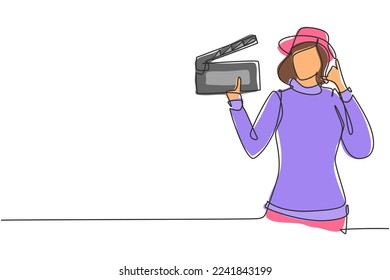 Single one line drawing female film director with call me gesture holding clapperboard and set the crew for studio shooting. Professional work. Continuous line draw design graphic vector illustration