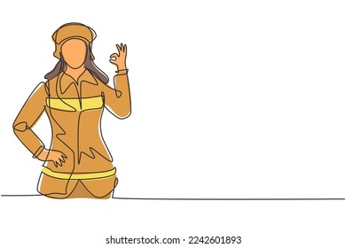 Single one line drawing female firefighter with uniform, gesture okay and hand on waist prepare to put out the fire that burned building. Modern continuous line draw design graphic vector illustration
