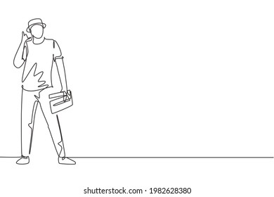 Single one line drawing film director stands with call me gesture holding clapperboard and prepare camera crew for shooting at tv studio. Continuous line draw design graphic vector illustration