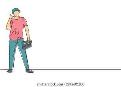Single one line drawing film director stands with call me gesture holding clapperboard and prepare camera crew for shooting at tv studio. Continuous line draw design graphic vector illustration