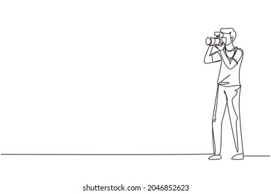 Single one line drawing happy professional photographer taking photo using dslr camera. Young male character shooting using lens camera. Modern continuous line draw design graphic vector illustration