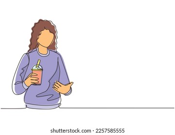 Single one line drawing happy young Asian woman showing boba milk tea, bubble milk drink, pearl milk tea. Tapioca tea, Asian exotic beverage concept. Continuous line draw design vector illustration