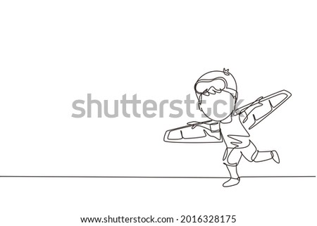 Single one line drawing happy kid boy play toy plane cardboard. Children playing toy plane cardboard, little cute kid in an astronaut costume. Continuous line draw design graphic vector illustration