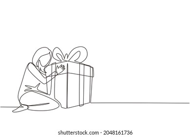 Single one line drawing joyful caucasian woman hugging huge birthday gift. Young satisfied female sitting near wrapped birthday gift box with ribbon. Continuous line draw design vector illustration