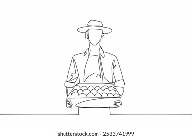 Single one line drawing a man wearing a hat carrying a wooden box filled with tomatoes. Gardener. A harvest very beneficial for the body. Fresh Tomato Day. Continuous line design graphic illustration