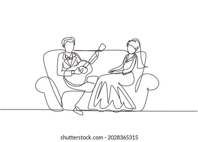 Single one line drawing married couple in love. Man with suit is playing guitar to his wife in living room on sofa. Woman with wedding dress listen and singing. Continuous line design graphic vector