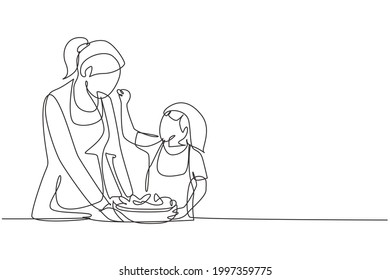 Una sola línea dibujando a la madre alimentando a su hija pequeña y delante de ella hay un bol lleno de ensalada. Cocinando juntos en una acogedora cocina. Ilustración gráfica de diseño de trazos de línea continua