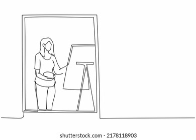 Single one line drawing woman painter drawing indoor near window. Female holding paint brush and palette, sketching on canvas. Artist painting at home. Continuous line draw design vector illustration