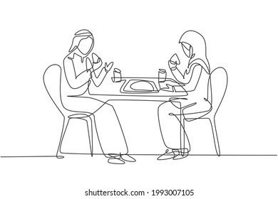 Single one line drawing young Arabian couple husband and wife having cake meal around table. Celebrate wedding anniversary with romantic dinner. Continuous line draw design graphic vector illustration