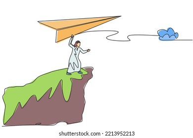 Single one line drawing of young Arabian business man fly paper plane from top of mountain. Business vision minimal metaphor concept. Modern continuous line draw design graphic vector illustration