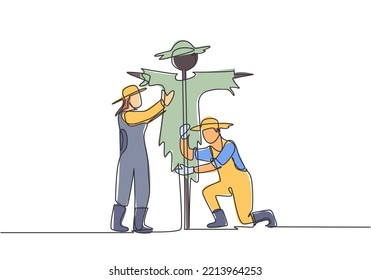 Single one line drawing of young couple farmer is installing a scarecrow to ward off pest birds. Farming challenge minimal concept. Modern continuous line draw design graphic vector illustration.