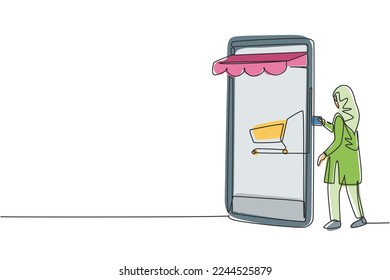 Una sola línea dibujando a una joven árabe insertando tarjeta de crédito en la pantalla del teléfono inteligente del dosel forestal con carro de la compra. Concepto de pago digital. Ilustración de líneas continuas moderna de diseño gráfico vectorial