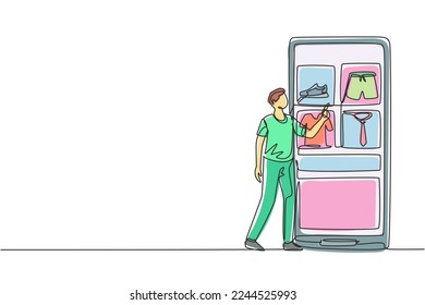 Single one line drawing young man choosing shopping items on a giant smartphone screen. Digital lifestyle with internet and gadgets concept. Continuous line draw design graphic vector illustration