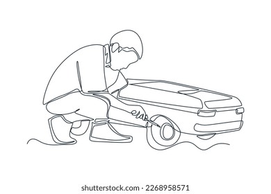Single one line drawing Young boy changing a tire on an toy car. Auto service concept. Continuous line draw design graphic vector illustration.