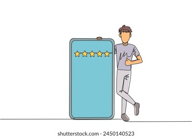 Single one line drawing young happy smiling man stands casually next to a large smartphone, other hand giving a thumbs up gesture. Give review 5 star. Continuous line design graphic illustration
