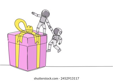 Single one line drawing young astronaut helps colleague climb the big gift box. Integrated teamwork to reach highest level for rewards. Helping each other. Continuous line design graphic illustration