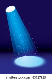 Single spotlight shining on stage with dust floating in air