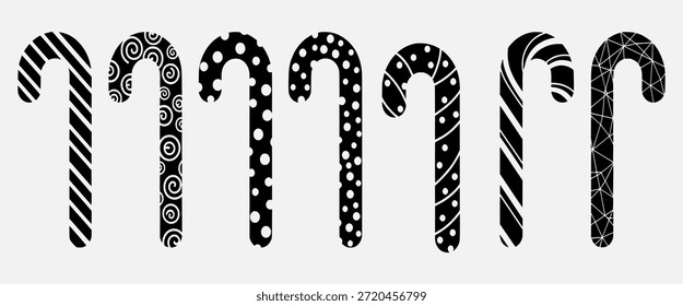 Seis bastones de caramelo con diferentes patrones en blanco y negro sobre un fondo blanco.