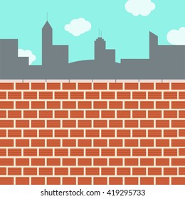 Skyline city behind the wall. Wall of clay bricks. Blue sky in the background.