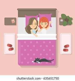 Sleeping couple with cat on the bed in the bedroom. Lesbian couple.