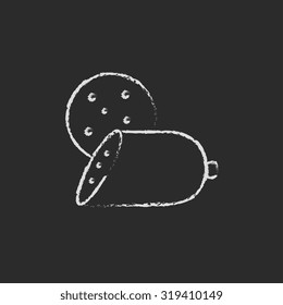 Sliced wurst hand drawn in chalk on a blackboard vector white icon isolated on a black background.