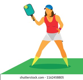 A slim, energetic young woman in a blue baseball cap and red T-shirt plays pickleball in the open air