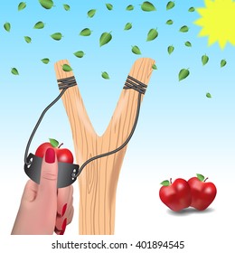 Slingshot against a background of falling leaves.Slingshot in a female hand.Apples instead of bullets.