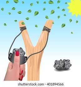 Slingshot against a background of falling leaves.Slingshot in a female hand.