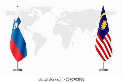 Slovenia and Malaysia flags for official meeting against background of world map.