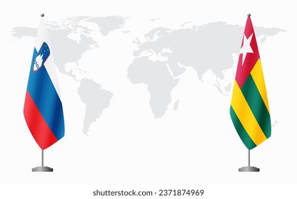 Slovenia and Togo flags for official meeting against background of world map.