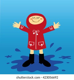 A small boy or girl in a red raincoat having fun splashing in the puddles after a shower of rain