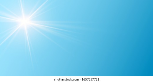 small and bright sun with long shining rays on blue sky background