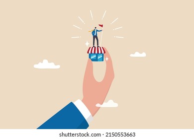 Small business idea, successful entrepreneur with small retail shop or storefront, shop owner or merchandise opportunity concept, success businessman holding winner flag on small store in giant hand.