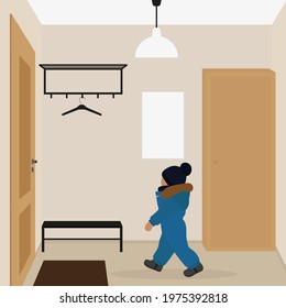 A small child in a hat and warm overalls walks to the door in the hallway