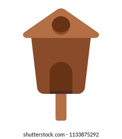 A small hut type wooden structure with hole depicting bird house
