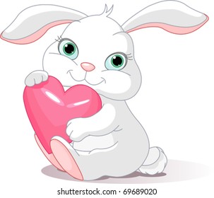 Small lovely rabbit holds love heart