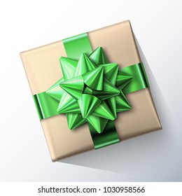 Small paper gift box with big glittering green bow and ribbons isolated on white background. Top view. Vector realistic festive illustration. Decoration element for holiday design.