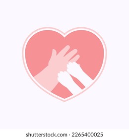 Small paws of cat on hand of kid, in pink heart shaped frame