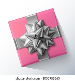 Small pink gift box with big glittering silver bow and ribbons isolated on white background. Top view. Vector realistic festive illustration. Decoration element for holiday design. 