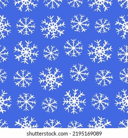 Small white ink snowflakes isolated on blue background. Cute monochrome Christmas seamless pattern. Vector simple flat graphic hand drawn illustration. Texture.