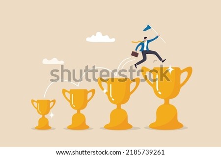 Small win or achievement to motivate to achieve bigger goal, strategy or inspiration to success, victory or win award concept, confident businessman jumping from small win trophy to get bigger one.