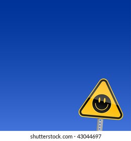 Small yellow road warning sign with black smiley symbol on sky background