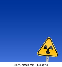 Small yellow road warning sign with radiation symbol on blue background