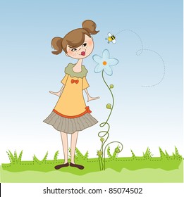 small young lady who smells a flower