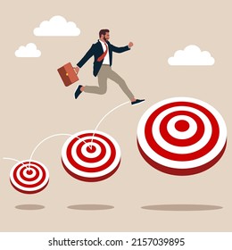 Smart businessman jumping on bigger and higher archery bull's eye target. Aspiration and motivation to achieve bigger business target, advancement in career or business growth concept.