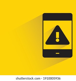 smart phone and caution symbol drop shadow on yellow background